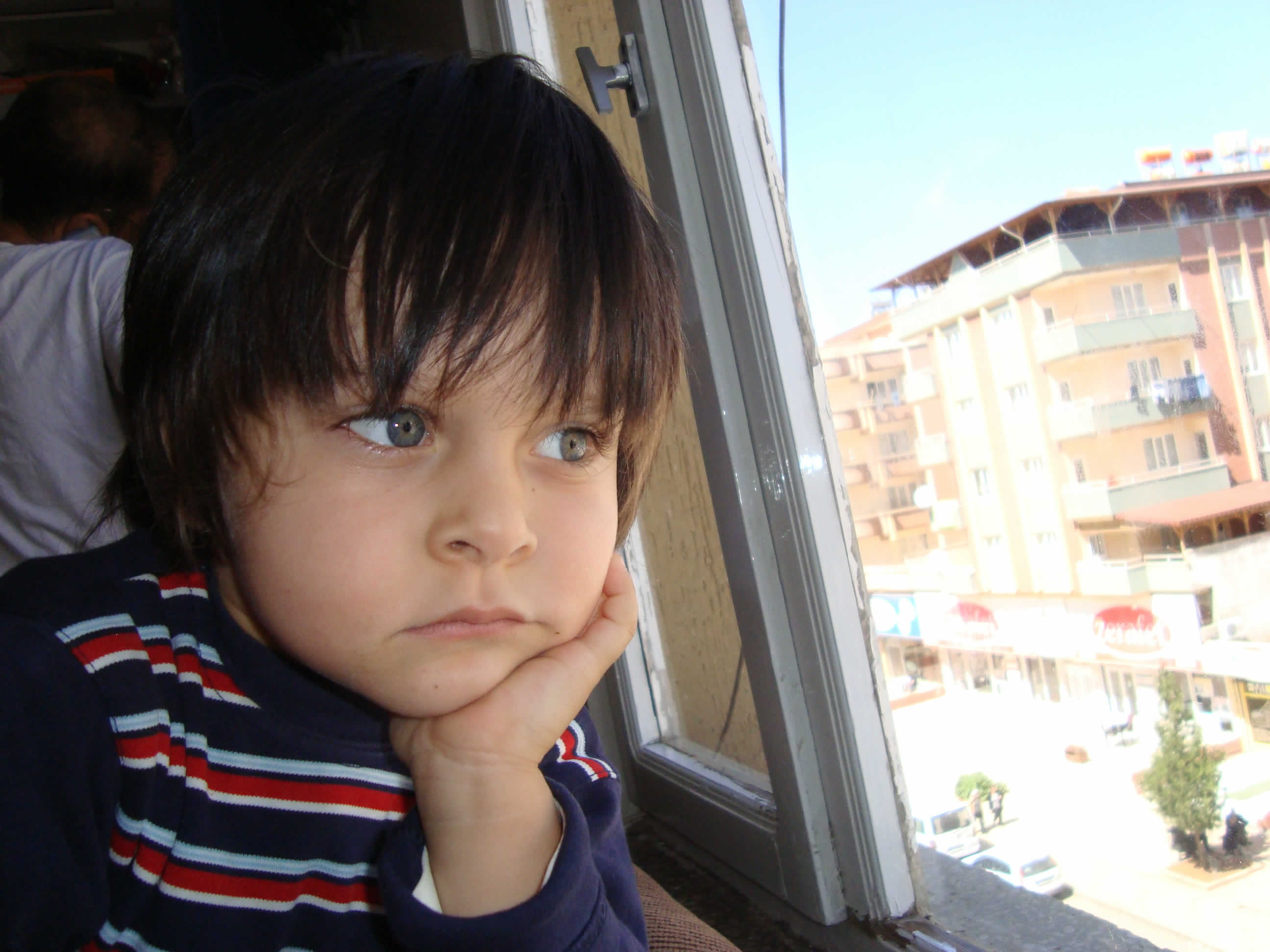 camdan dışarı bakan çocuk